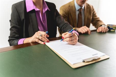 person signing document in an office